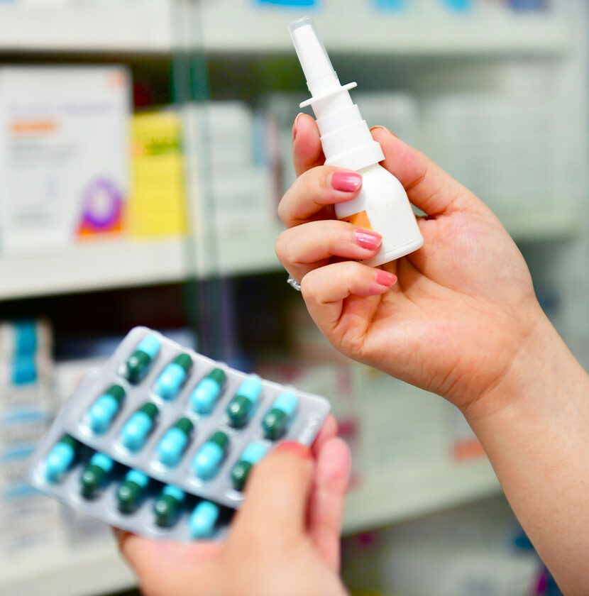 pharmacist holding nasal spray medicine and capsule pack