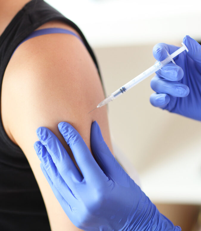 Young doctor giving a patient injection.